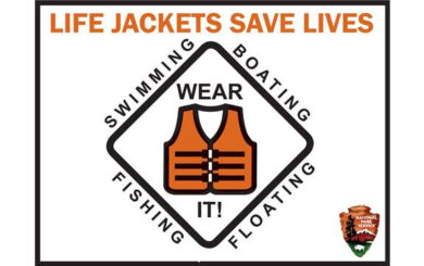safety sign reading "life jackets save lives: Wear it! swimming - boating - fishing - floating