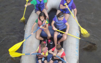 family of seven on a raft looking down from a bridge